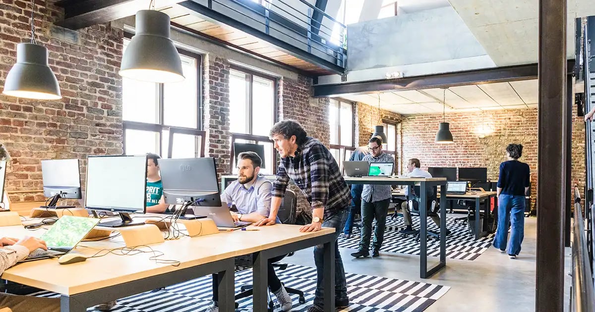 Boss-leaning-over-desk-coaching-employee